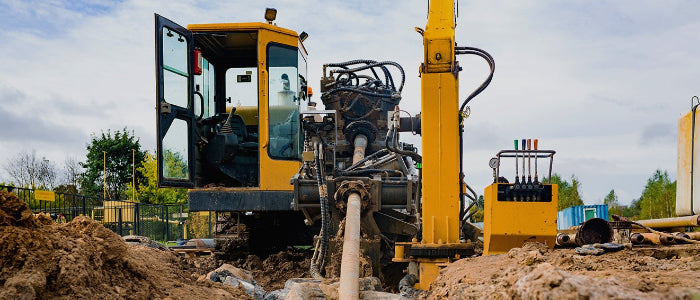 Yellow Horizontal Directional drilling machine on a construction site with a clear sky.