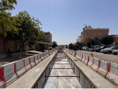 underground cable installation  site with barriers and vehicles on a street of Saudi Arabia with buildings in the background